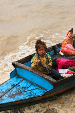 SIEMREAP, KHMER REPUBLIC - FEBRUARY 23 : Unidentified Khmer girl and snake round her neck is in beggar way of life in the greatest freshwater lake in the world on February 23, 2013 at Tonle Sap Lake, Siemreap, Khmer Republic.のeditorial素材
