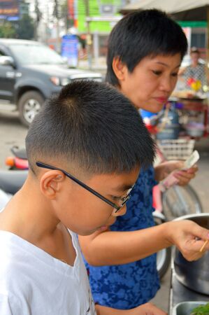 SATUK, BURIRAM - FEBRUARY 9 : Unidentified boy and woman are shopping on February 9, 2013 at municipality market, Satuk, Buriram, Thailand.のeditorial素材