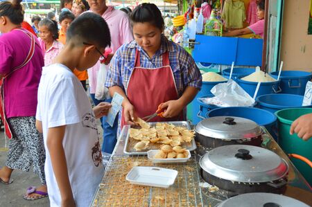 SATUK, BURIRAM - FEBRUARY 9 : Unidentified boy is buying foods on February 9, 2013 at municipality market, Satuk, Buriram, Thailand.のeditorial素材