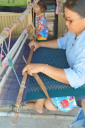 MAHASARAKHAM, THAILAND - APRIL 30 : Unidentified woman is weaving clothes on April 30, 2013 in Mak Ya village, Muang, Mahasarakham, Thailand. Clothes weaving is rural Thai traditional manufacturing.のeditorial素材