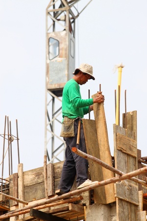 MAHASARAKHAM, THAILAND - MAY 22 : Unidentified worker is working on city hall building site on May 22, 2013 in Mahasarakham, Thailand.のeditorial素材