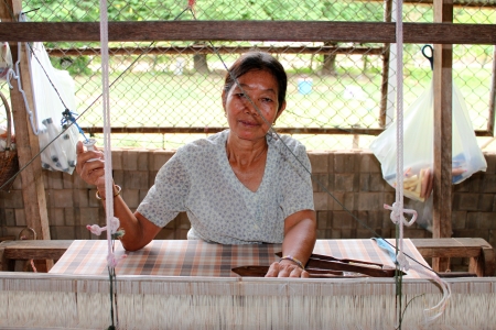 MAHASARAKHAM, THAILAND - JULY 17 : Unidentified woman is weaving clothes at Nong No Tai village on July 17, 2013 in Mahasarakham, Thailand. Fabric weaving is traditional Thai  manufacturing.のeditorial素材