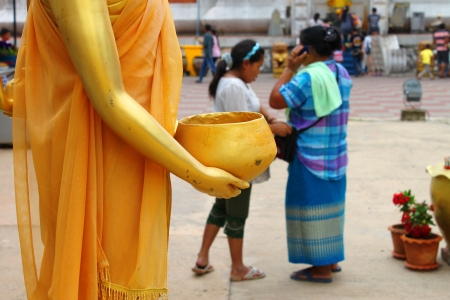 MAHASARAKHAM, THAILAND - JULY 20 : Unidentified people donate money and worship Buddha statue and make religious merit in Buddhist Lent festival at Nadun Pagoda on July 20, 2013 in Mahasarakham, Thailand. のeditorial素材