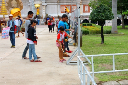 MAHASARAKHAM, THAILAND - JULY 20 : Unidentified children aged 7 - 11 years and people make religious merit in Buddhist Lent festival at Nadun Pagoda on July 20, 2013 in Mahasarakham, Thailand. のeditorial素材