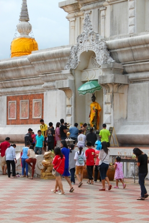 MAHASARAKHAM, THAILAND - JULY 22 : Unidentified child aged 4 - 7 years and people walk with lighted candles in hand around Nadun Pagoda and worship Buddha statue in Buddhist Lent festival on July 22, 2013 in Mahasarakham, Thailand.のeditorial素材