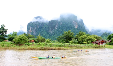 VANG VIENG, LAO P D R  - AUGUST 24   Unidentified tourists are traveling on long-tailed boat trip in Song River on August 24, 2013 in Vang Vieng, Lao P D R のeditorial素材