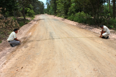 MAHASARAKHAM, THAILAND - SEPTEMBER 16   Unidentified men survey local road for public  construction on September 16, 2013 in Mahasarakham, Thailand のeditorial素材