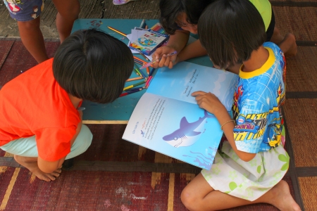 MAHASARAKHAM, THAILAND - OCTOBER 17   Unidentified children aged 6-10 years are reading a book in public healthy mobile project at Non Mi village on October 17, 2013 in Muang Mahasarakham, Thailand のeditorial素材