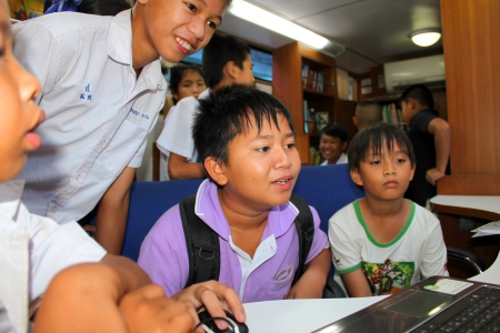 MAHASARAKHAM - SEPTEMBER 24   Unidentified children aged 7-12 years are playing video game from public mobile library at Nong Ku village on September 24, 2013 in Muang Mahasarakham, Thailand のeditorial素材