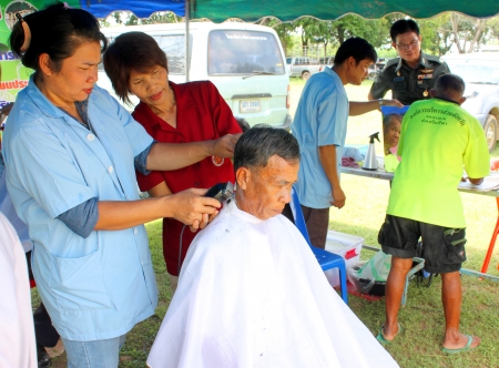 MAHASARAKHAM - SEPTEMBER 24   Unidentified man is getting a haircut by hairdresser in public healthy mobile services at Nong Ku village on September 24, 2013 in Muang Mahasarakham, Thailand のeditorial素材