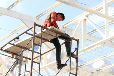 MAHASARAKHAM - DECEMBER 4   Unidentified man works on the roof at building site of Taksila hotel on December 4, 2013 in Mahasarakham, Thailand のeditorial素材