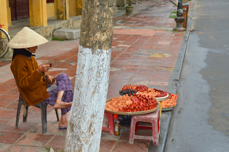 HOI AN, VIETNAM - MARCH 15   Unidentified woman is selling souvenirs at walking street on March 15, 2014 in Hoi An, Vietnam  Hoi An is world heritage old town with old aged traditionally kept cultural activities, habits and customs のeditorial素材