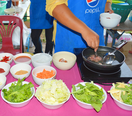 MAHASARAKHAM - JULY 7   Woman chef is preparing food at Khwao Subdistrict Administrative Organization market on July 7, 2014 in Mahasarakham, Thailand のeditorial素材