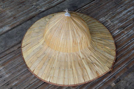 farmer hat made from dried leaves of the nipa palm on bamboo stretcher tableの写真素材