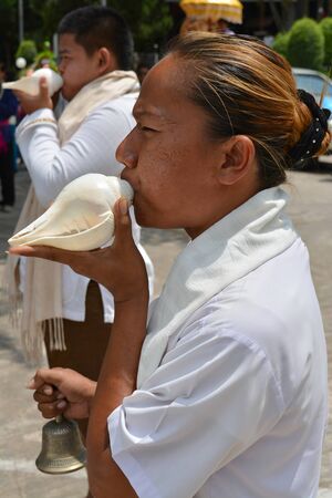 MAHASARAKHAM - APRIL 12 : Priests are blowing conch and performing Brahma worship ceremony in songkran festival at Mahasarakham university on April 12, 2015 in Mahasarakham, Thailand.のeditorial素材