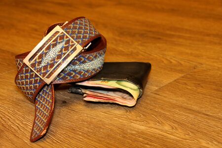 stingray skin belt and money pouch on wooden floor in dimlight room