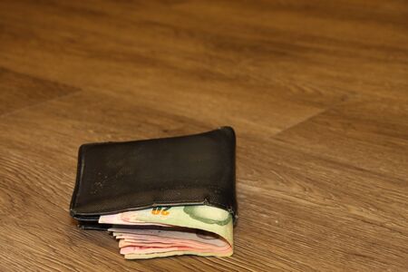 money pouch on wooden floor in dimlight roomの写真素材