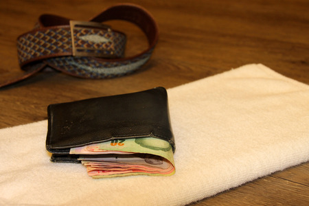 money purse and towel on wooden floor in the morning light roomの写真素材