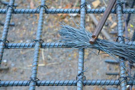 bend tool with metal wire and foundation post metal and concrete beam metal on the ground at...