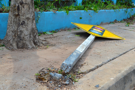 broken traffic light sign on footpath of the roadの写真素材