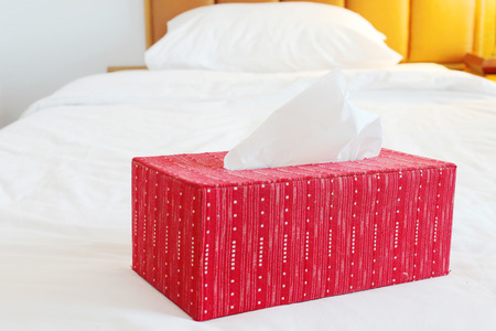 red tissue paper box on spacious bed of low cost hotel in Thailandの写真素材