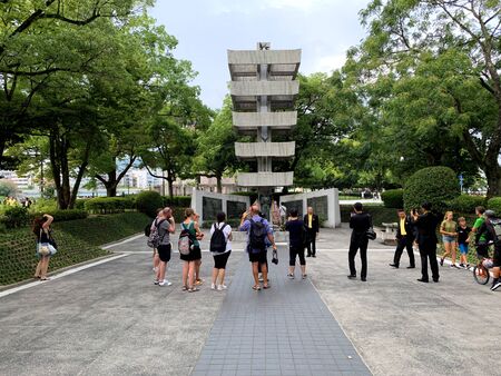 Hiroshima, Japan - August 21, 2019: Tourists visit statue at memorial tower to the mobilized students, part of the Hiroshima Peace Memorial on August 21, 2019 in Hiroshima, Japan.のeditorial素材