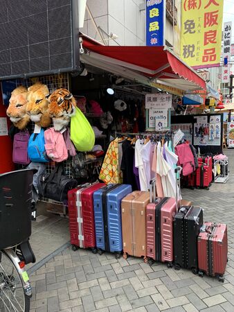 OSAKA, JAPAN - AUGUST 24, 2019 : Suitcases for sale are displayed in front of storefront at Doutonbori street, Numba and Shinsaibashi the famous large market and metropolitan area on August 24, 2019 in Osaka, Japan.のeditorial素材