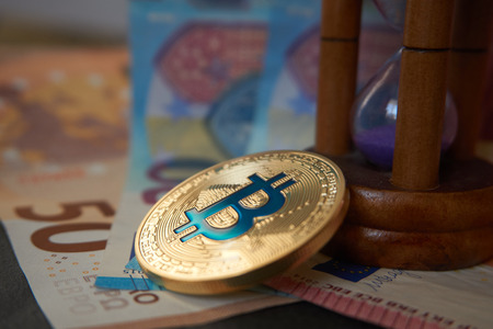Crypto currency concept - A bitcoin with euro billsの写真素材