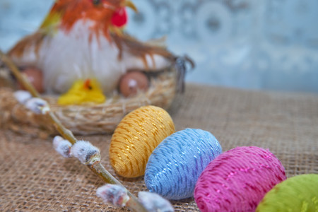 Colorful easter eggs and willow branch on natural jute fabric background. The concept of a happy Easterの写真素材