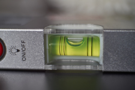 Close up of spirit level meter tool out of balance, motion, selective focusing.