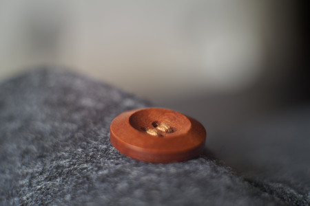 Sewn button playing with light, shadow, reflection and surfaces, selective focus.の写真素材