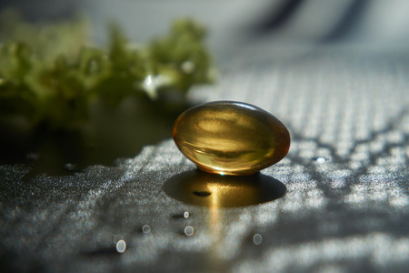 Close up golden color oil capsule and iceberg lettuce. Health care, diet, weight loss, healthy lifestyle concept.の写真素材