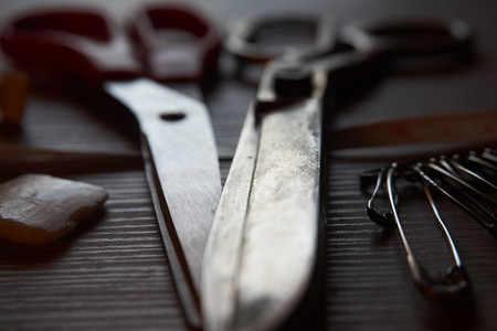 Old metal scissors, chalk, safety pins and tailor measure tape on grey wooden background. Retro sewing accessories for home sewing and repair of clothing.の写真素材