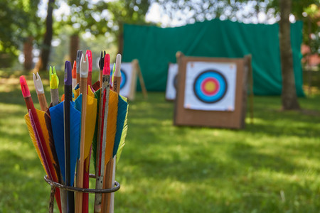 Aim concept with a low angle view across green grass of targets and a arrows in the foregroundの写真素材