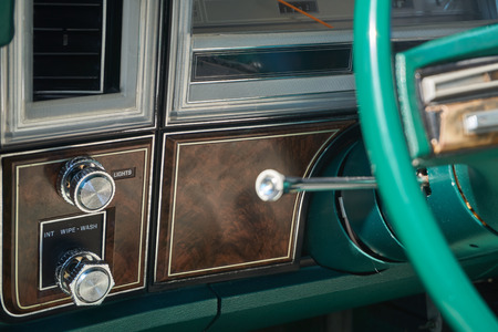 Dashboard and steering column of an old vehicle with wood veneer finish and green steering wheelの写真素材