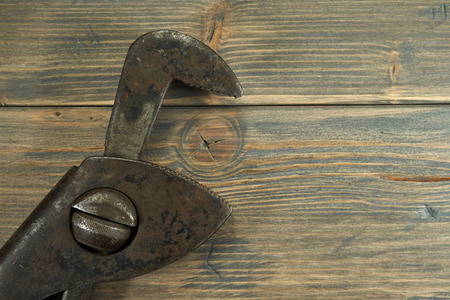 Vintage rusty pipe wrench on a weathered wood background. Plumbing concept top view and copy spaceの写真素材