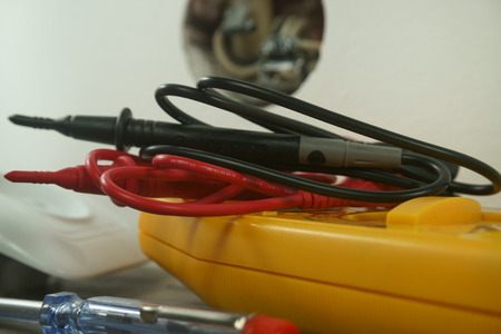 Tools for wiring a domestic electrical wall socket on the floor alongside the plastic cover and open socket showing internal circuitryの写真素材