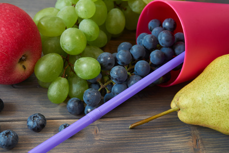 Mix of juicy summer fruits and berries. Pear, apple, green and blue grapes, blueberries on gray rustic wood background space for textの写真素材