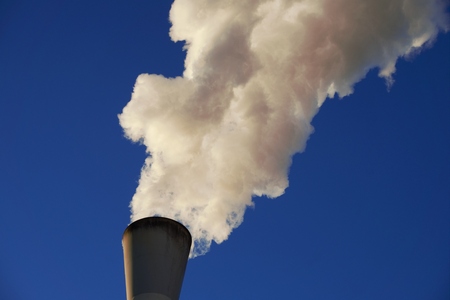 White smoke coming out of industrial chimney with blue sky background. Air pollution, greenhouse...