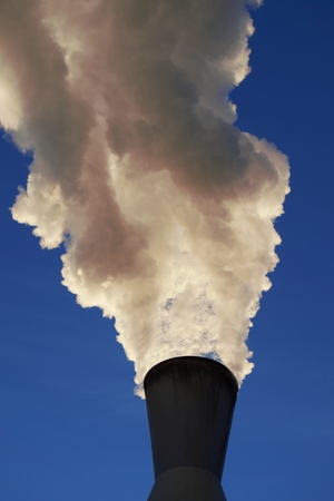 White smoke coming out of industrial chimney with blue sky background. Air pollution, greenhouse effect and global warming problem concept.の写真素材