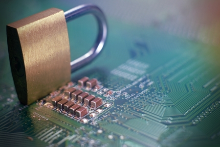 Golden lock sitting on electric circuit as concept of internet data security. Close-up full frame viewed from above with copy spaceの写真素材