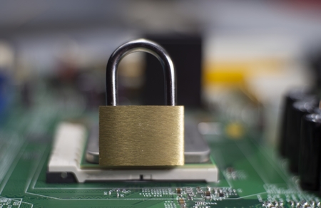 Closed lock on a computer mainboard chip. Digital security, locking processor conceptの写真素材
