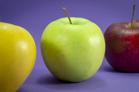 Group of yellow apple on a purple background. Color trends concept with copy spaceの写真素材