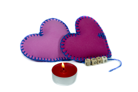 Hand stitched textile hearts with word Love on blocks threaded on strings isolated on white background for romantic relationship, Valentines Day, broken heart and conceptの写真素材