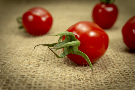 Fresh red cherry tomato on burlap canvas backgroundの写真素材