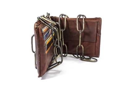 Brown leather wallet bound by an old metal chain on white in a conceptual image of monetary security or controlling spendingの写真素材