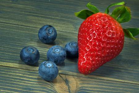 Strawberry and blueberries viewed in close-up on wooden backgroundの写真素材
