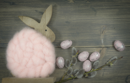 Easter still life or card design with cute little woolly rabbit decoration, fresh spring flower and foil wrapped Easter eggs with copy space for your holiday messageの写真素材