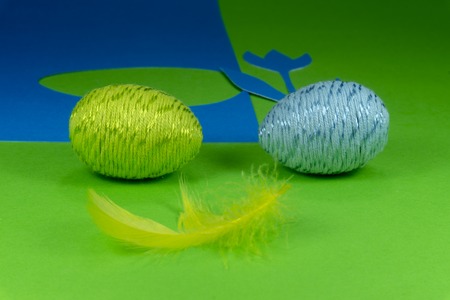 Willow buds and Easter eggs in close-up as a set of decoration on spring theme in Christianity, placed on green background with flower cutout of blue paperの写真素材