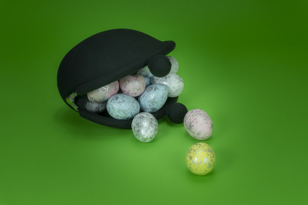 Black retro coin purse and Easter eggs on green background, Easter holiday cost conceptの写真素材